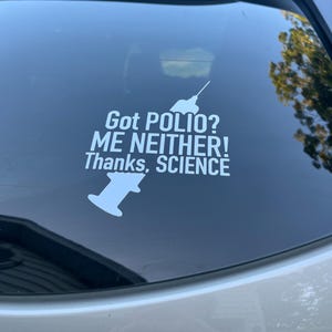 May include: White vinyl decal with the text "Got POLIO? ME NEITHER! Thanks, SCIENCE" and a syringe graphic. The decal is applied to a car window.