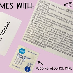 K&ouml;nnte beinhalten: Das Bild zeigt einen wei&szlig;en Vinyl-Rakel, eine Applikationsanleitung und ein steriles Alkoholtupfer. Die Anweisungen erkl&auml;ren, wie man einen Vinyl-Aufkleber anbringt. Das Pad dient zur Reinigung der Oberfl&auml;che.