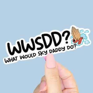 Può includere: Un adesivo bianco con la scritta "WWSDD? WHAT WOULD SKY DADDY DO?" in nero, bordata di bianco. L'adesivo presenta anche un'illustrazione di mani che pregano con nuvole e una manica rossa. L'adesivo è tenuto in mano con smalto rosa.