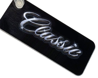 May include: A black keychain with a silver 'Classic' inscription. The keychain has a silver metal ring and a white plastic loop.