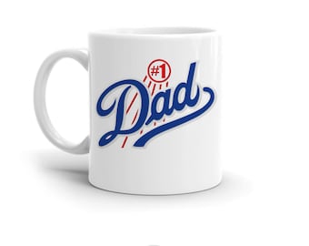 May include: White ceramic mug with a blue and red graphic that says "#1 Dad" in a stylized font.