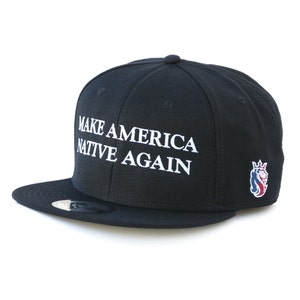 May include: A black baseball cap with the text "Make America Native Again" in white lettering. A small red, white, and blue logo is on the right side of the cap.