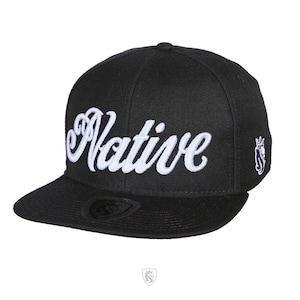 May include: A black and white baseball cap with the word "Native" embroidered in white on the front. The cap has a black brim and a white logo on the side.