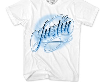 May include: White t-shirt with a blue airbrushed design of the name "Justin" with a small heart above the name.