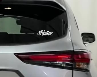 May include: A silver car with a white vinyl decal that says "Native" on the back window.