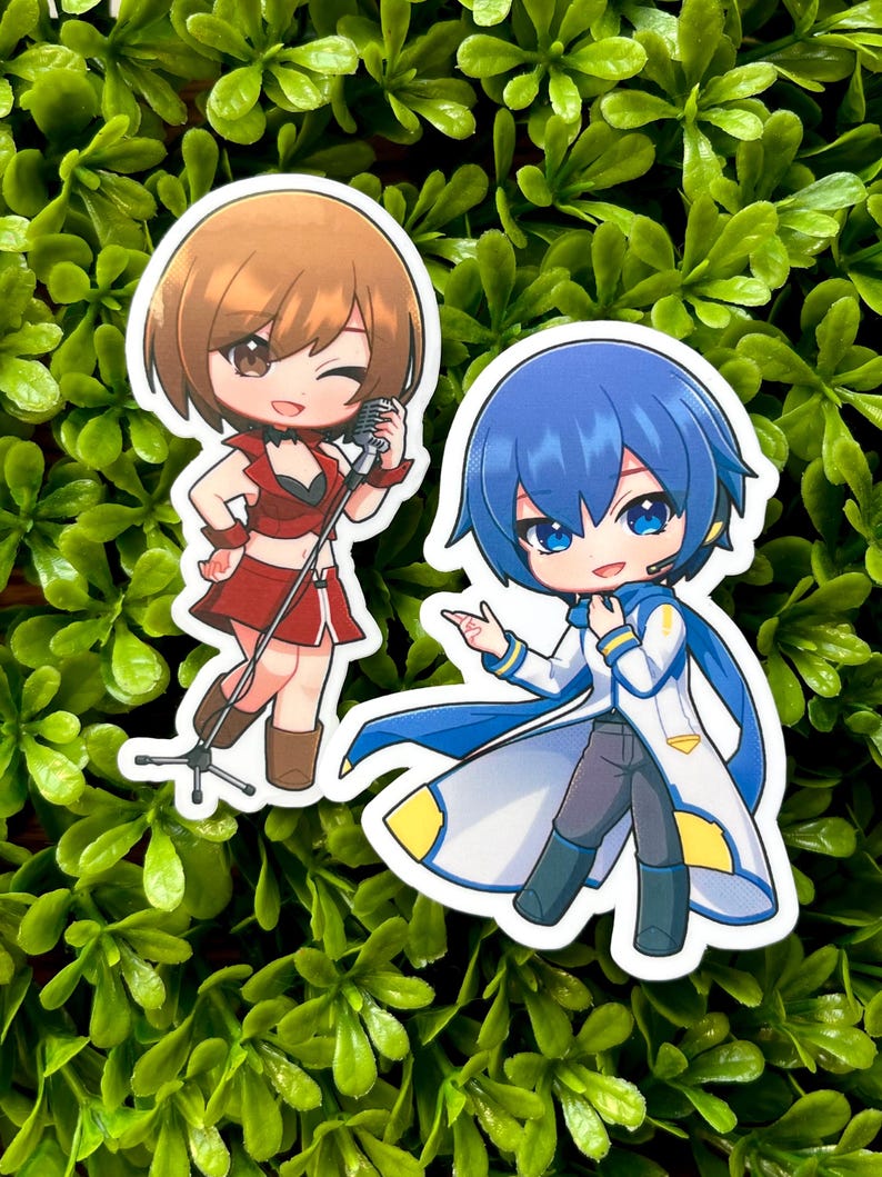 May include: Two anime-style stickers featuring cartoon characters. One sticker shows a brown-haired character in a red outfit with a microphone. The other sticker depicts a blue-haired character in a white and blue outfit.