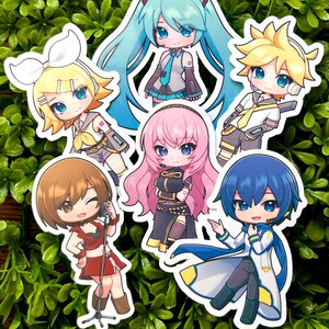May include: A collection of colorful anime-style stickers featuring various characters with large eyes and stylized outfits. The stickers showcase characters with blue, yellow, pink, and brown hair, set against a green leafy background.
