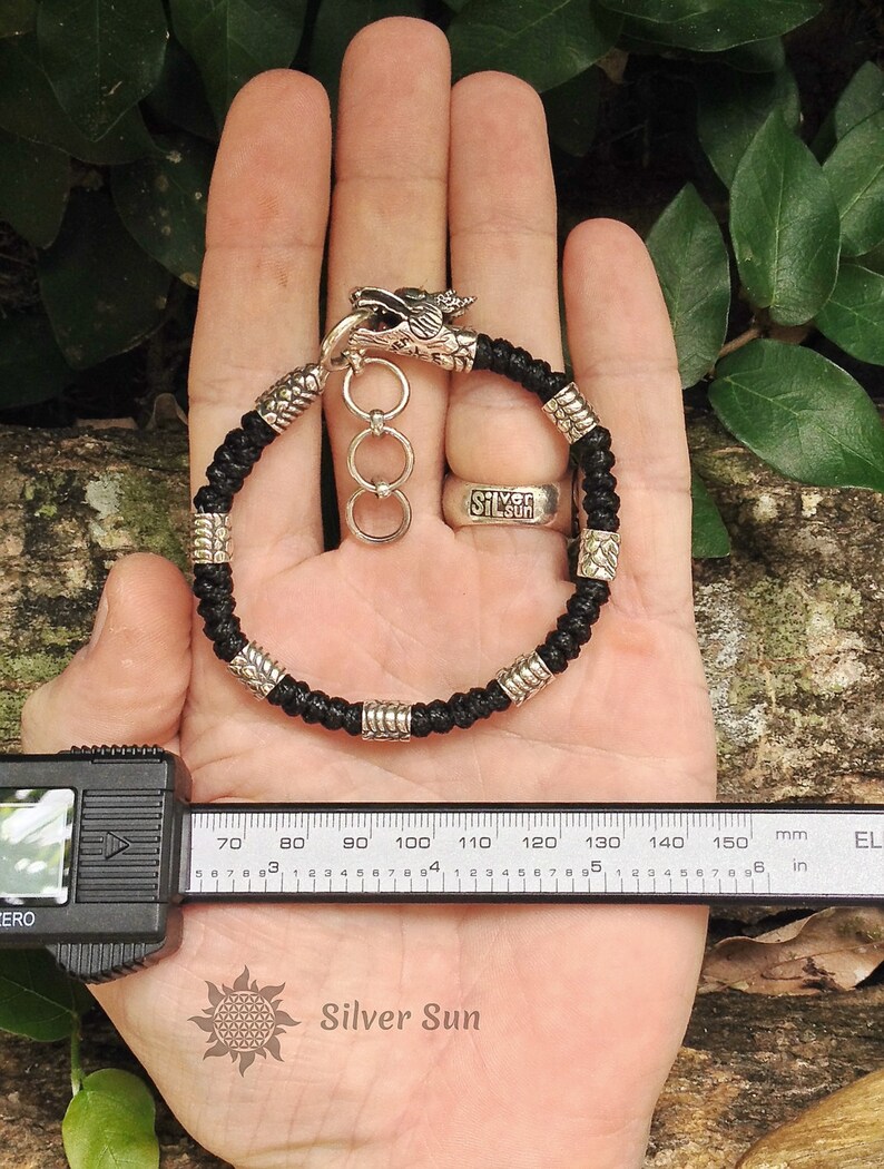 Puede incluir: Pulsera trenzada negra con cierre de cabeza de drag&oacute;n plateado y cuentas plateadas. La pulsera mide 14 cm de largo.
