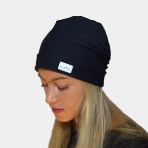 May include: A black beanie with a small white label that says "Lavi" in blue lettering.