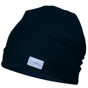 May include: A dark blue beanie with a small white label that says "Jumi" on it.