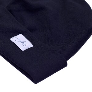 May include: A black beanie with a white label that says "Jui."