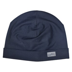 May include: A dark blue beanie with a small white label that says "Journ" on it.