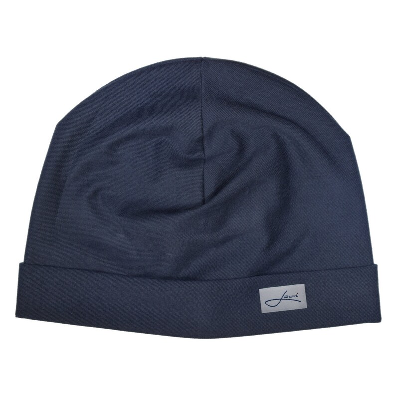 May include: A dark blue beanie with a small white label that says "Journ" on it.