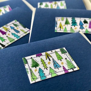 Handgemaakte (x5) kerstkaarten. Kleine, handgeschilderde aquarel kerstboomontwerpen op rijke, donkerblauwe kaart.