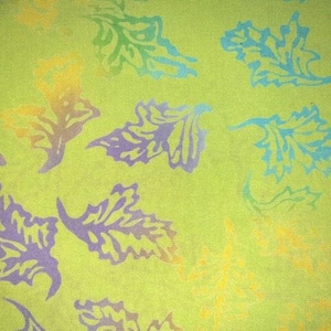 May include: A lime green fabric featuring a repeating pattern of stylized leaves printed in various colors including light blue, purple, and yellow. The leaf shapes are scattered across the surface, creating a vibrant and colorful botanical design.