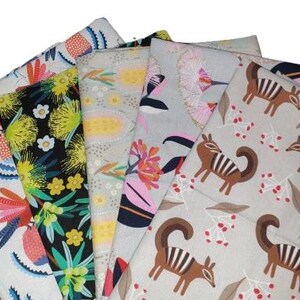 May include: A collection of five folded fabric swatches featuring diverse patterns. Designs include white with colorful abstract floral motifs, black with yellow and green botanical prints, light yellow with subtle dots, and light gray with brown numbat illustrations.