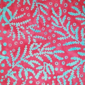 May include: A textile with a repeating pattern of teal coral-like shapes and small circles on a deep red background. The design has a batik-like appearance, with soft edges and variations in colour intensity. The pattern is reminiscent of coral.
