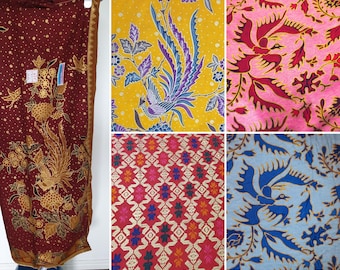 May include: A collection of five fabric swatches featuring intricate batik patterns. The designs include a deep red cloth with gold phoenix motifs, a yellow background with blue birds, a pink floral print, a red geometric pattern, and a light blue bird print.