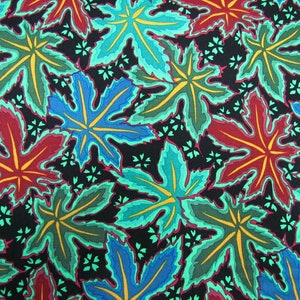 May include: A black fabric with a repeating pattern of colourful leaves. The leaves are in shades of red, blue, green, and yellow. The background is black with small white dots.