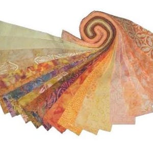 May include: A collection of fabric strips in a variety of warm colors, fanned out to display the different patterns and textures. The fabrics range from light yellow to deep orange, with floral and geometric designs. The end of the fabric is rolled up.