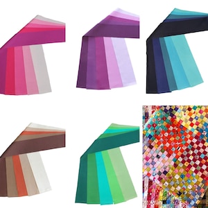 May include: A selection of fabric table runners in shades of pink, purple, blue, brown, and green. The runners are arranged in a fan shape, displaying the colour gradients. A patchwork quilt is also visible.