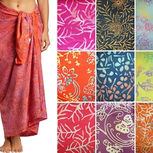 May include: A sarong wrap skirt featuring a vibrant orange and purple floral pattern tied at the waist. The image also displays a grid of nine fabric swatches in various colors including pink, black, blue, green, and orange with floral and butterfly prints.