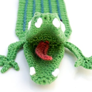 Puede incluir: Marcap&aacute;ginas de cocodrilo verde tejido a crochet con la boca muy abierta, dientes blancos y una lengua rosa.