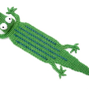 Puede incluir: Marcap&aacute;ginas de cocodrilo verde tejido a crochet con rayas azules y ojos blancos.
