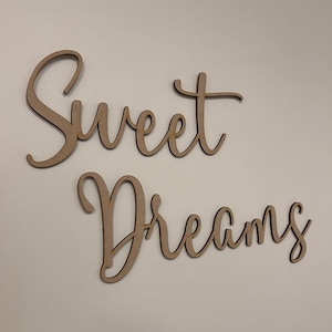 May include: Wooden wall decor with the words "Sweet Dreams" in a cursive font.