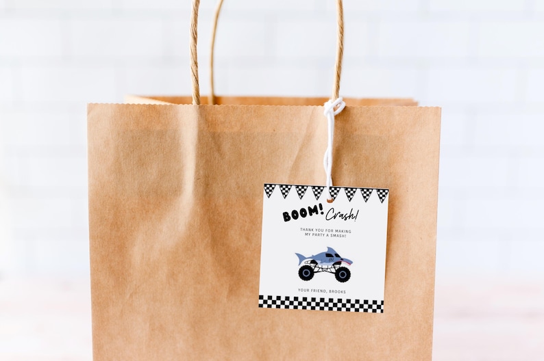 May include: A brown paper gift bag with a white string handle. A thank you tag is attached to the bag with black and white checkered borders. The tag says "BOOM! Crash! Thank you for making my party a smash! Your friend, Brooke". A cartoon monster truck is pictured on the tag.