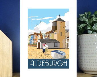 May include: A colorful illustration of a seaside town with a couple walking on the beach. The town has colorful buildings and a tall tower. The text "ALDEBURGH" is at the bottom of the image.