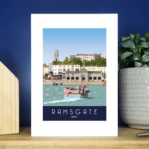 Puede incluir: Una ilustración colorida de Ramsgate, Kent, Inglaterra. La imagen muestra un barco con globos rosas, gaviotas y una vista de la costa de la ciudad.