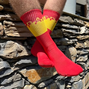 May include: Red and yellow striped socks with the word "ESPAÑA" written in yellow letters on the socks.