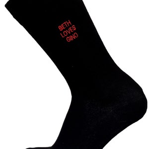 May include: Black socks with red embroidered text that reads "Beth loves Gino".