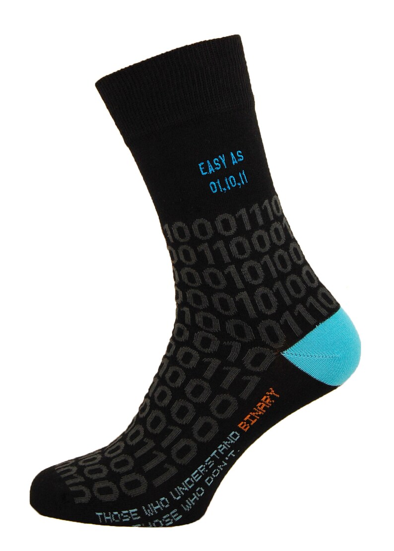 Op de afbeelding: Zwarte sokken met een blauw en oranje ontwerp met de tekst "EASY AS 01,10,11" en "THOSE WHO UNDERSTAND BINARY. THOSE WHO DON'T." De sokken zijn bedekt met een patroon van 0's en 1's.