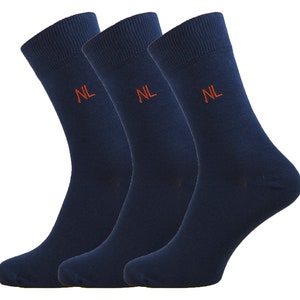 May include: Three pairs of dark blue socks with the letters "NL" embroidered in orange on each sock.