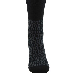 Op de afbeelding: Zwarte sokken met een patroon van herhalende binaire code-nummers in grijs.