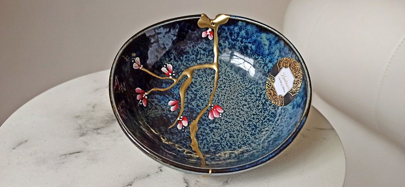 Kintsugi cassé et réparé sur bol en céramique fabriqué au Japon. Fleurs peintes à la main. image 1