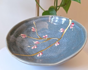 Kintsugi cassé et réparé sur un bol en céramique fabriqué au Japon. Fleurs peintes à la main.