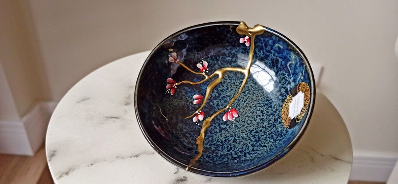 Kintsugi roto y reparado sobre cuenco de cerámica hecha en Japón. Flores pintadas a mano. imagen 4