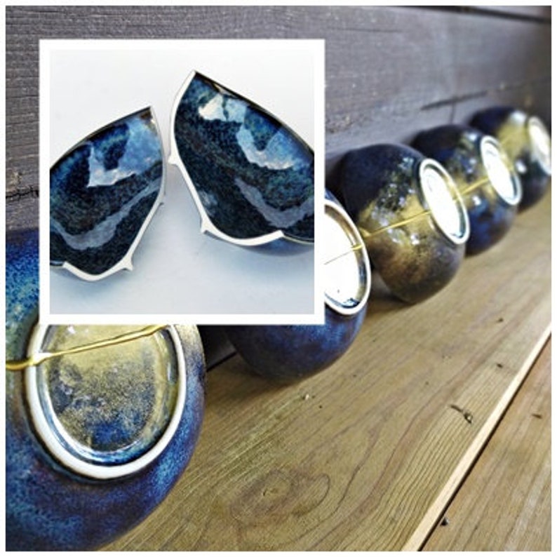 Peut inclure: Un ensemble de cinq bols en c&eacute;ramique bleus et dor&eacute;s avec un gla&ccedil;age mouchet&eacute;. Les bols sont dispos&eacute;s en rang&eacute;e sur une surface en bois. Les bols sont tous de formes et de tailles l&eacute;g&egrave;rement diff&eacute;rentes.