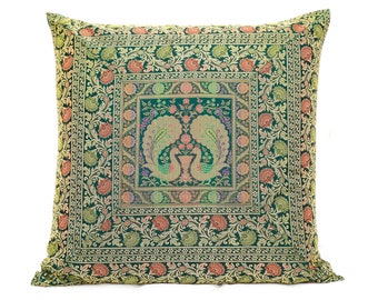 May include: A green throw pillow with a gold and red floral pattern and two peacocks in the center.