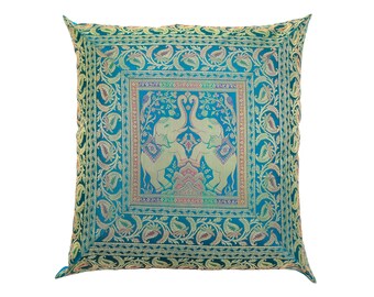 May include: Square decorative pillow with a teal background and gold floral and elephant design. The center features two elephants facing each other. The pillow has a detailed border with a paisley pattern. A colorful accent piece for a sofa or bed.