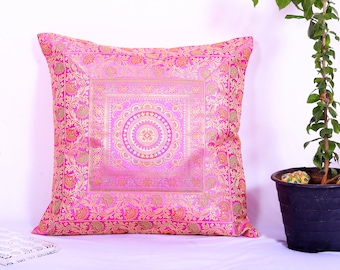 May include: A pink and gold decorative cushion with a floral pattern and a mandala design in the centre.