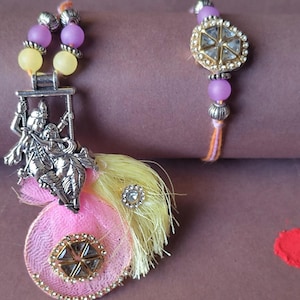 Devotionalie Radha Krishna Rakhi-Lumba Paar Bhai-Bhabhi Handgefertigter Rakhi-Lumba mit Idol Charm Set Raksha Bandhan Geschenk mit Roli Chawal,Karte