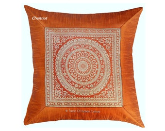 May include: A square throw pillow with a chestnut brown outer border and a red inner square with a white and gold mandala design. The text "Taste Of Indian Culture" is printed in white at the bottom of the pillow.