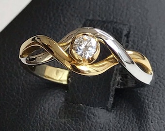 Ring in white and yellow gold intertwined with a central brilliant cut diamond of 0.12 carats