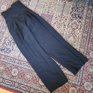 May include: Black high-waisted pants with pleats and a wide leg.