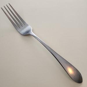 May include: A silver fork with a long, slender handle and a polished finish.