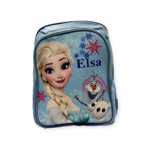 May include: A light blue backpack featuring the character Elsa from the movie Frozen. The backpack has a large image of Elsa, the word "Elsa", and a cartoon image of Olaf the snowman. The backpack has a zipper closure and side pocket.